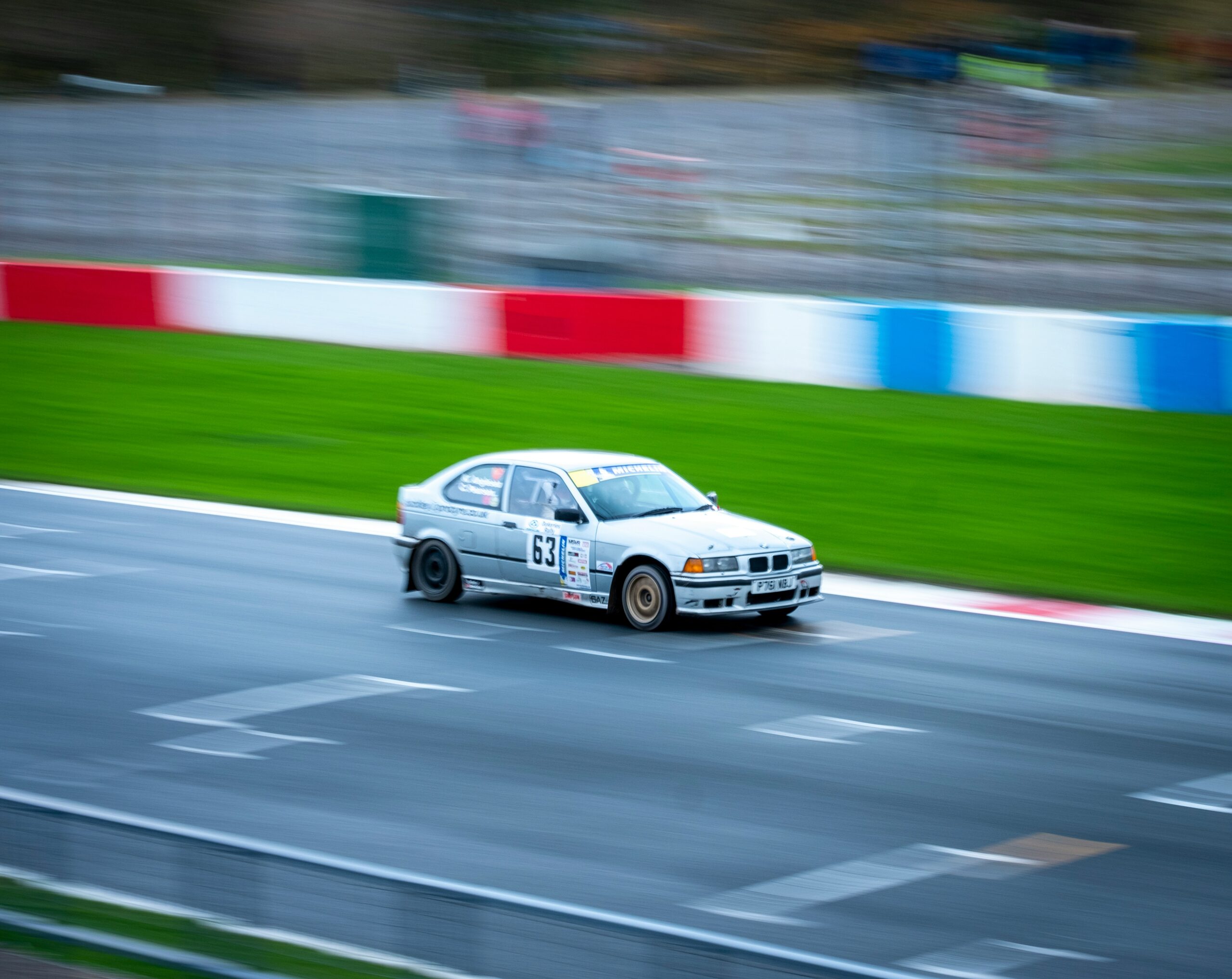 Foto zeigt ein autorennen mitzieher von einem weissen bmw rennwagen