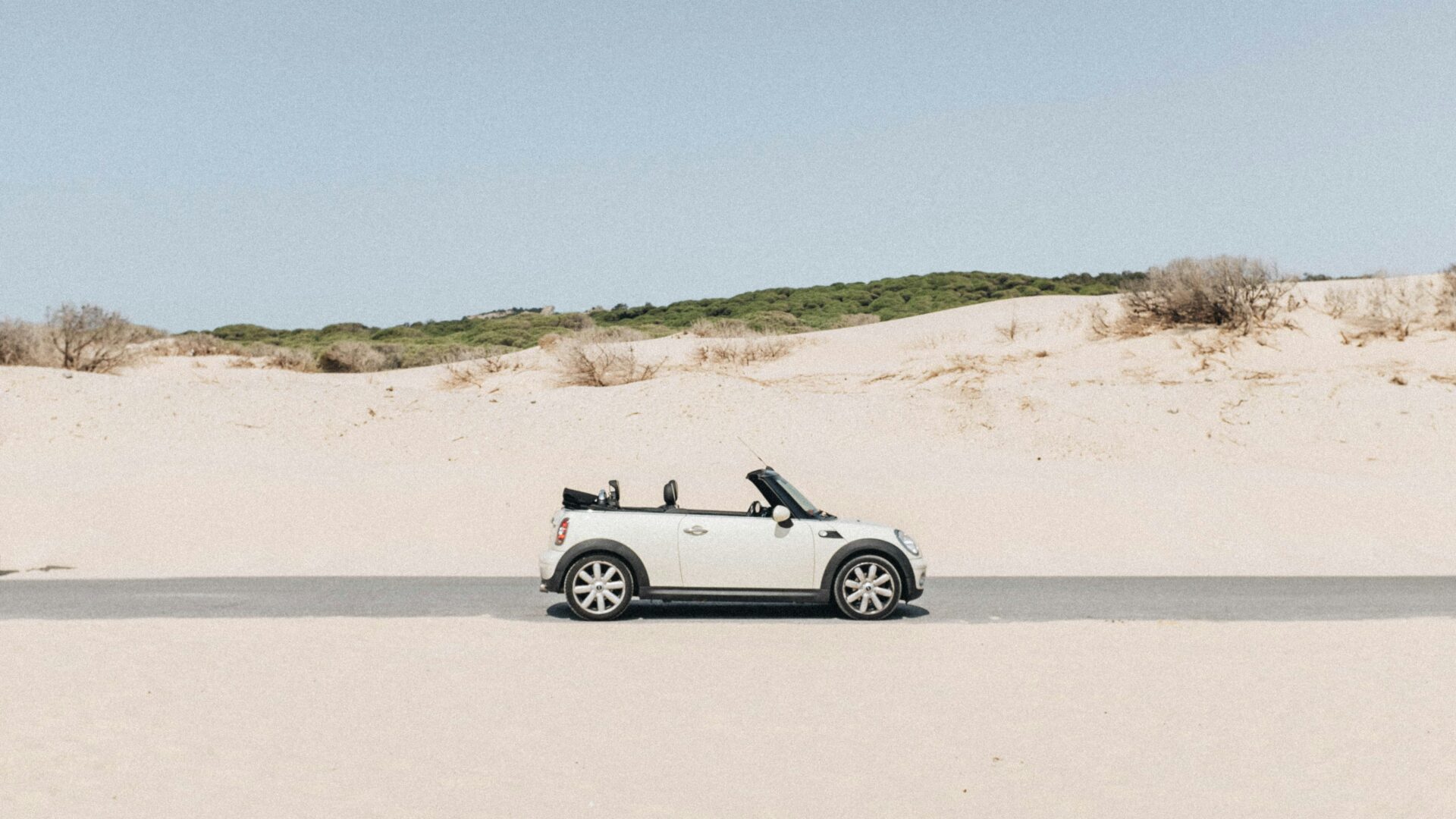Kleiner weisser mini fotografiert auf strasse in der totalen am strand