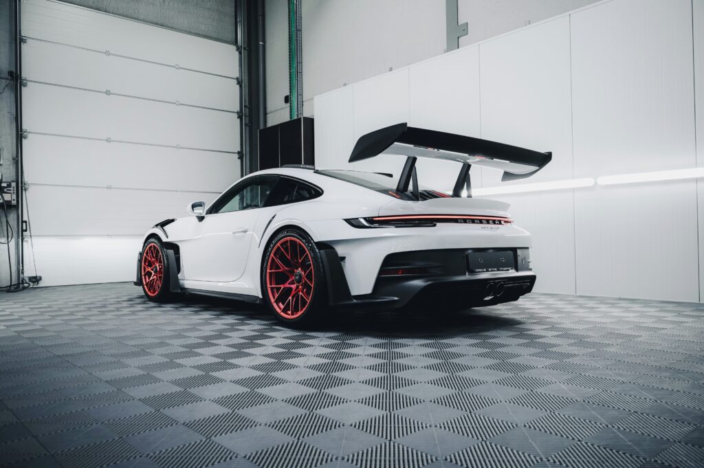 Weisser porsche in werkstatt von leicht unten fotografiert