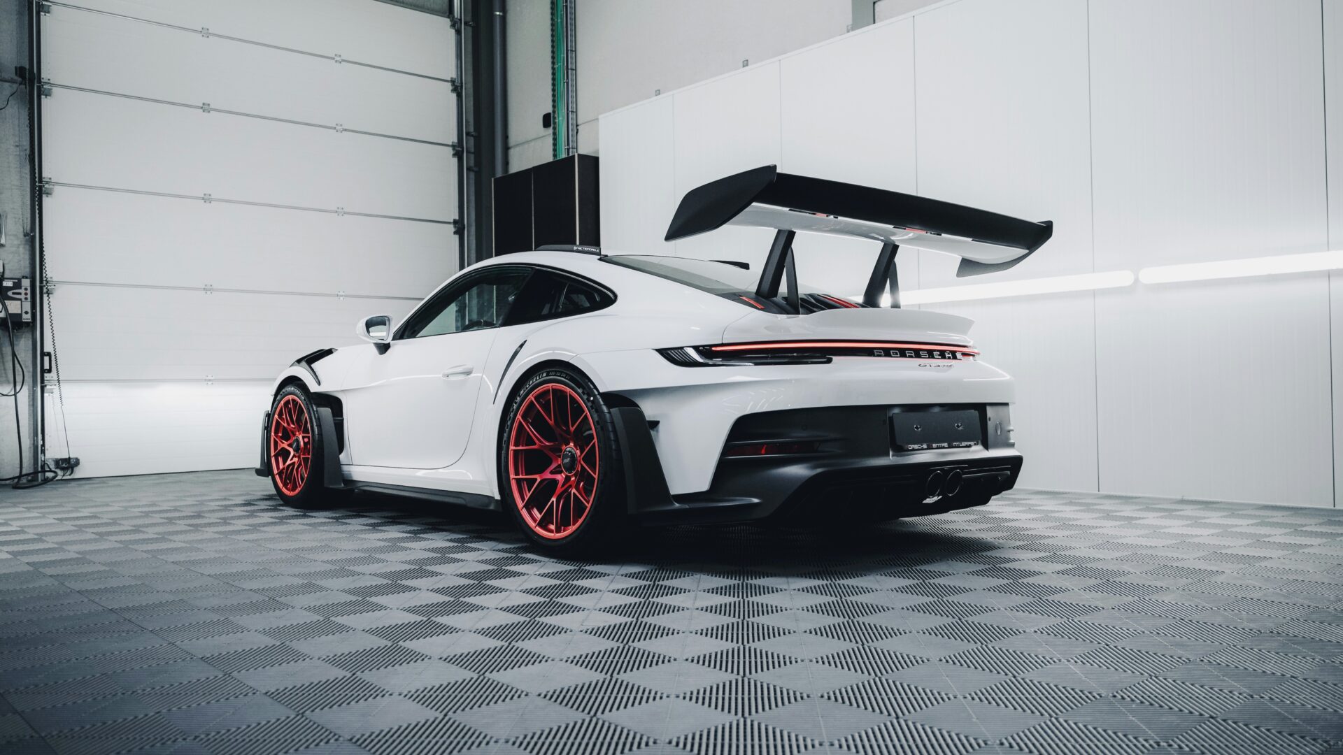 Weisser porsche in werkstatt von leicht unten fotografiert