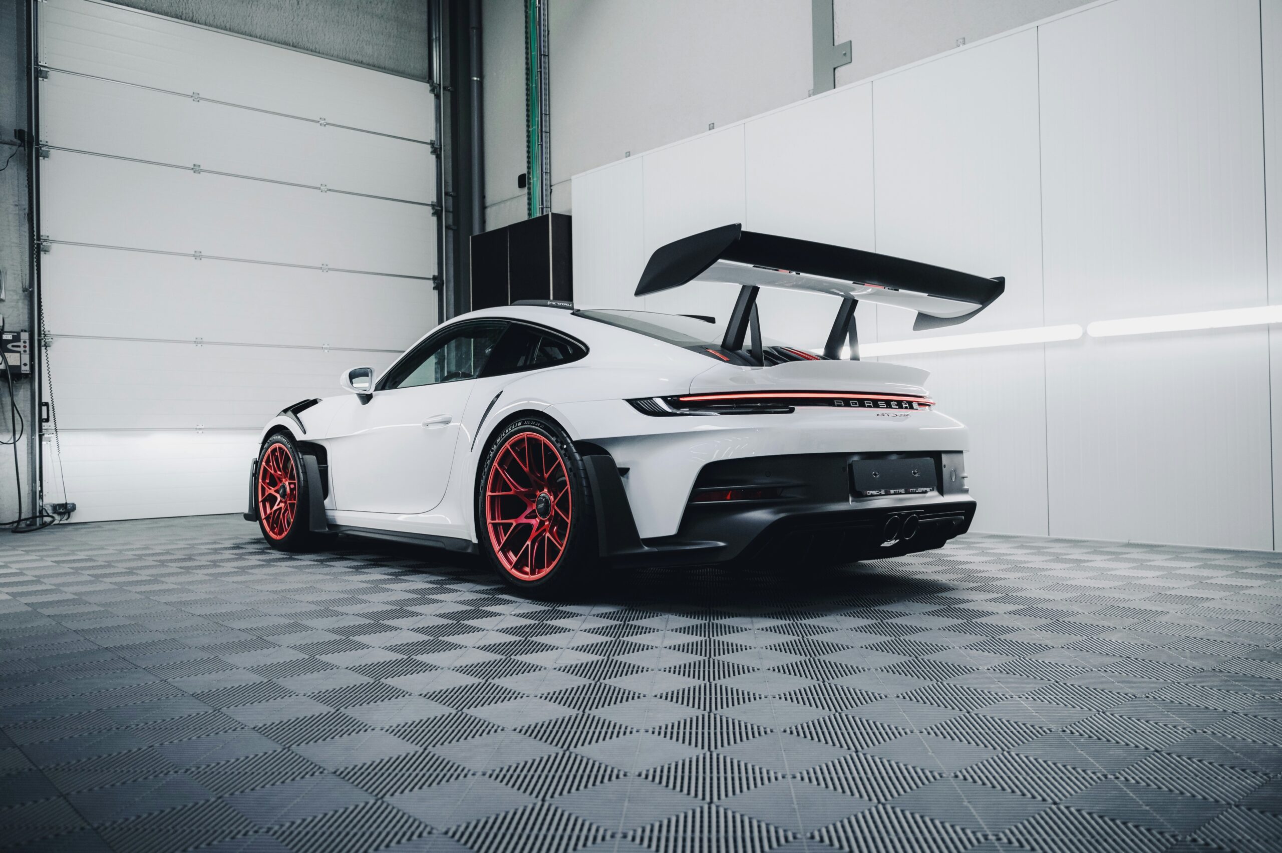 Weisser porsche in werkstatt von leicht unten fotografiert